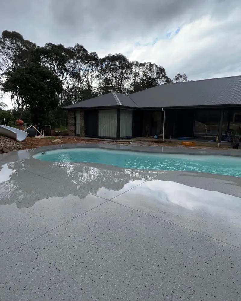 The finished curved pool surround and pool at Bargo, with the house behind