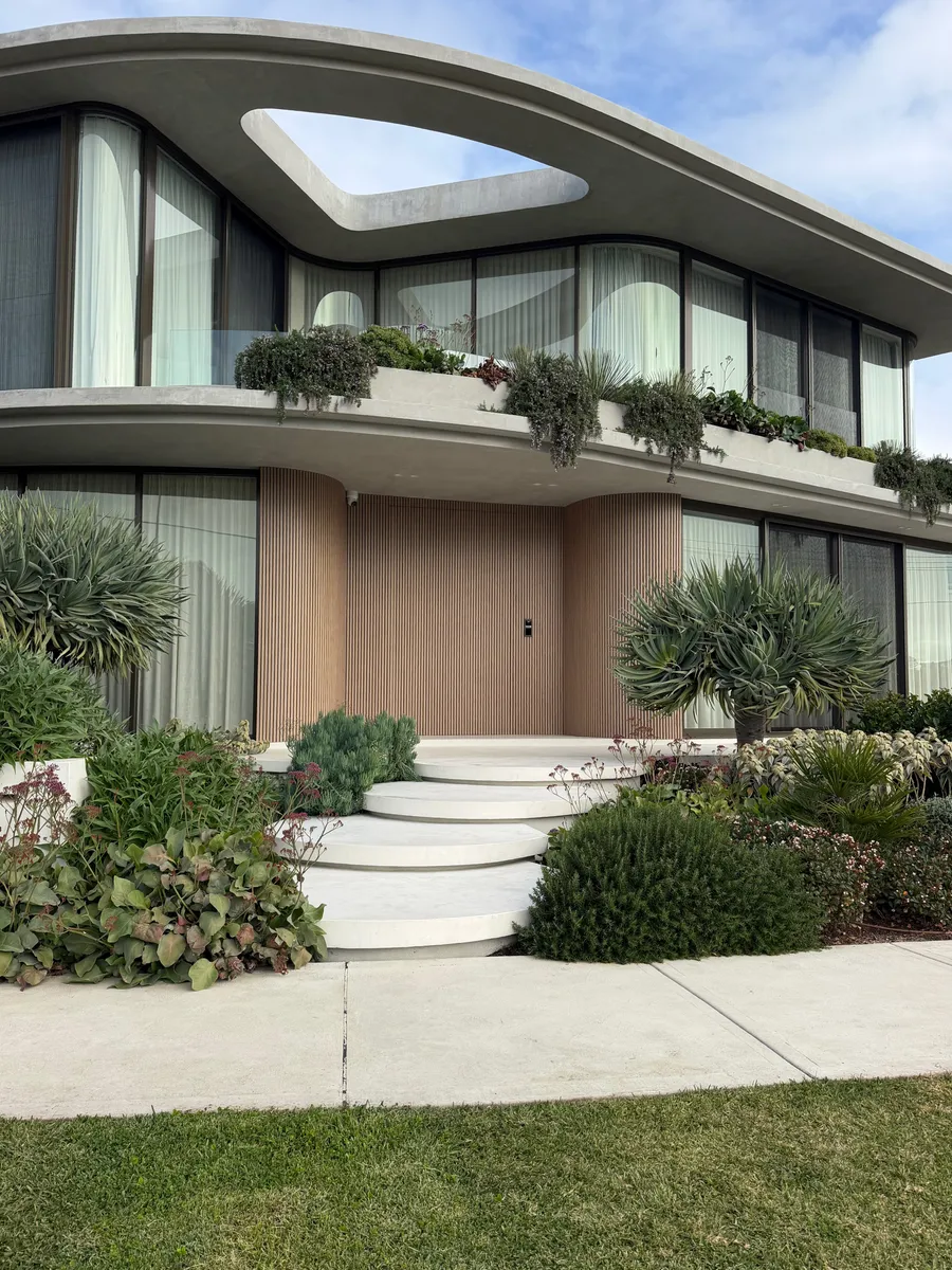 Rounded floating concrete steps in Geostone Snow leading to the front porch of a home in Drummoyne NSW