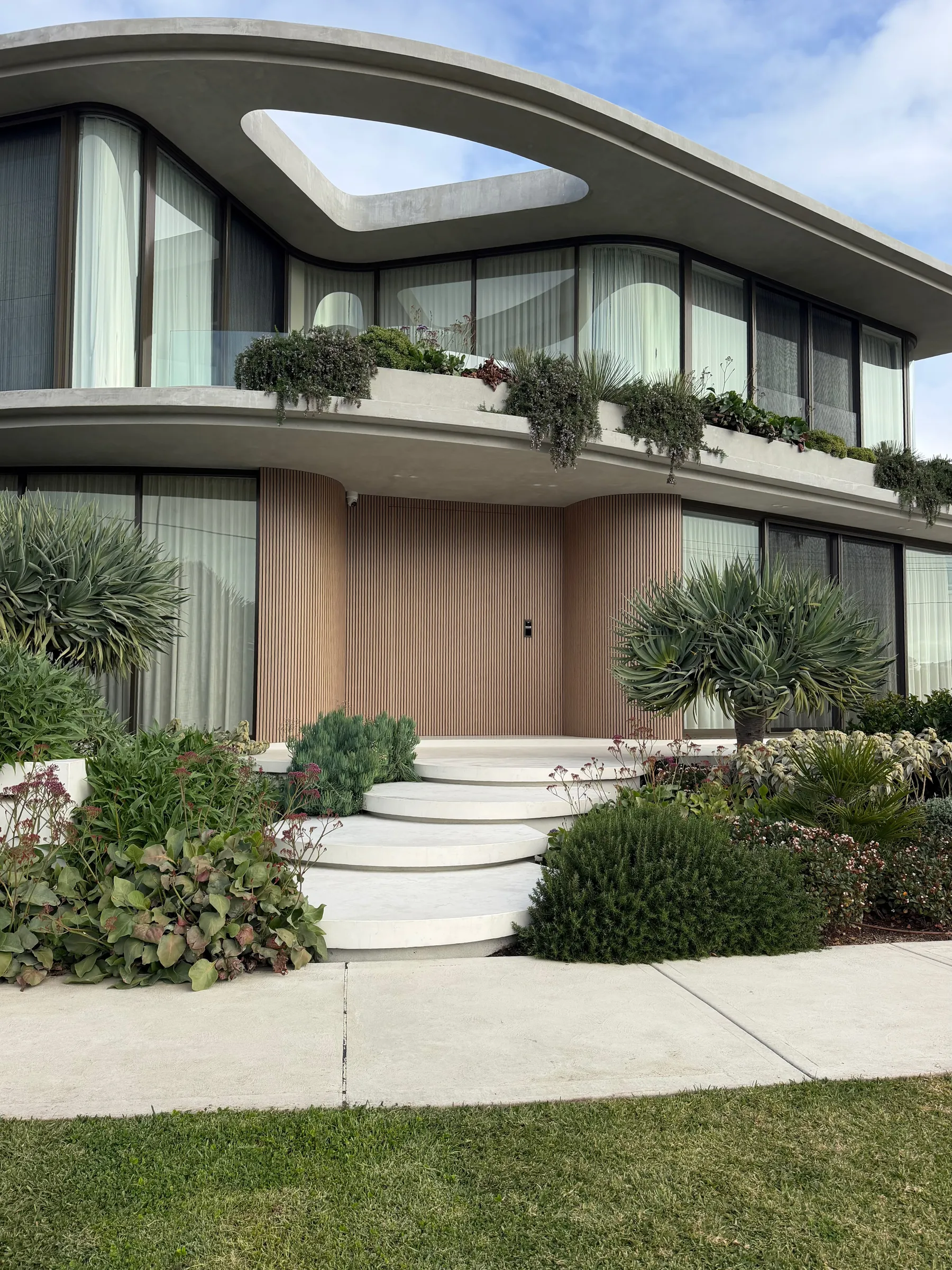 Rounded floating concrete steps in Geostone Snow leading to the front porch of a home in Drummoyne NSW
