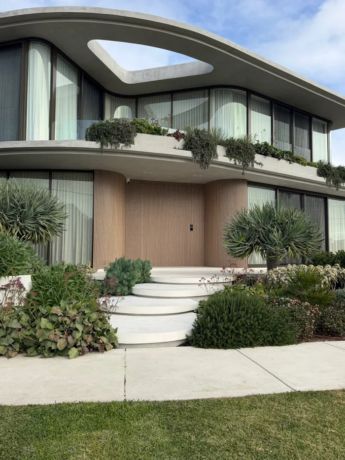 Rounded floating concrete steps in Geostone Snow leading to the front porch of a home in Drummoyne NSW
