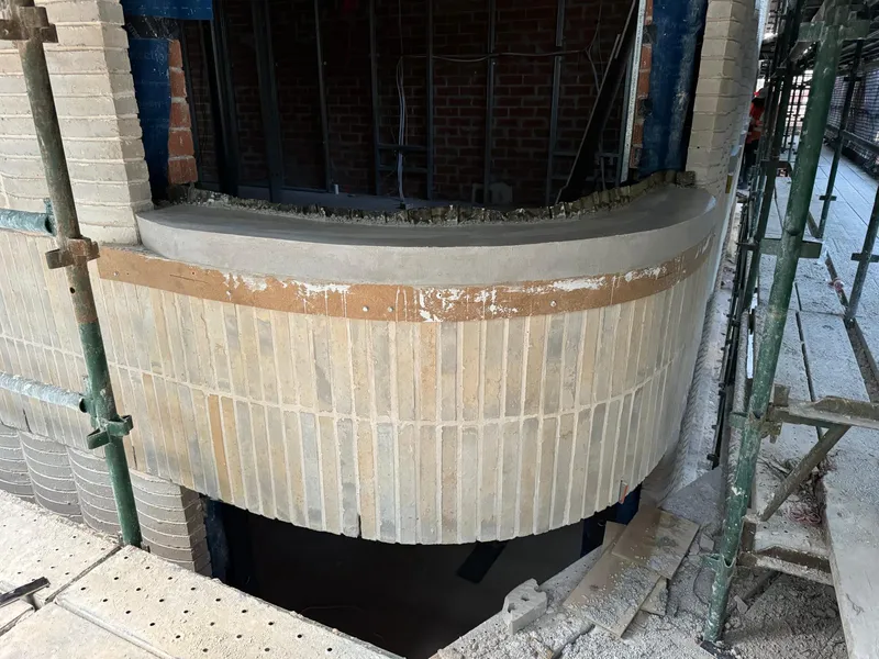 A finished curved window sill against the brick backing wall, different light