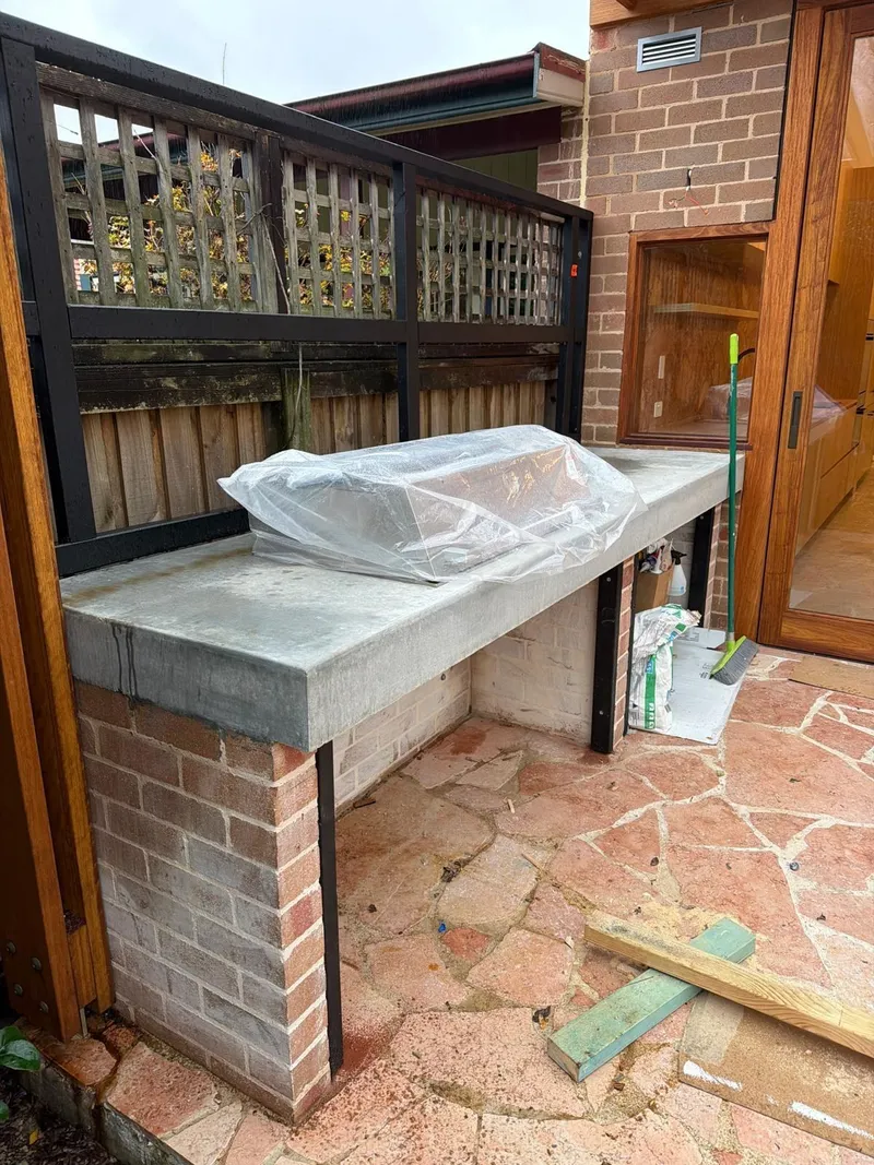 The finished concrete benchtop at Habberfield, still wrapped, seen from the side patio