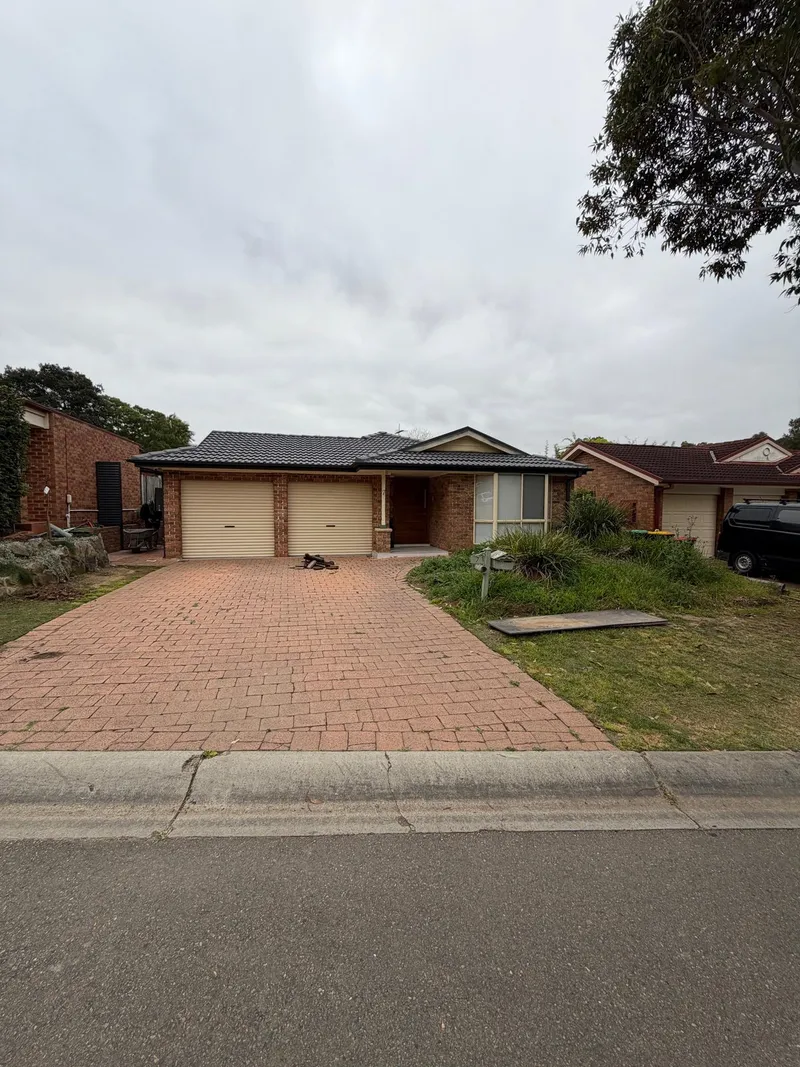 The Holsworthy home before work started, with the old brick paver driveway and front yard