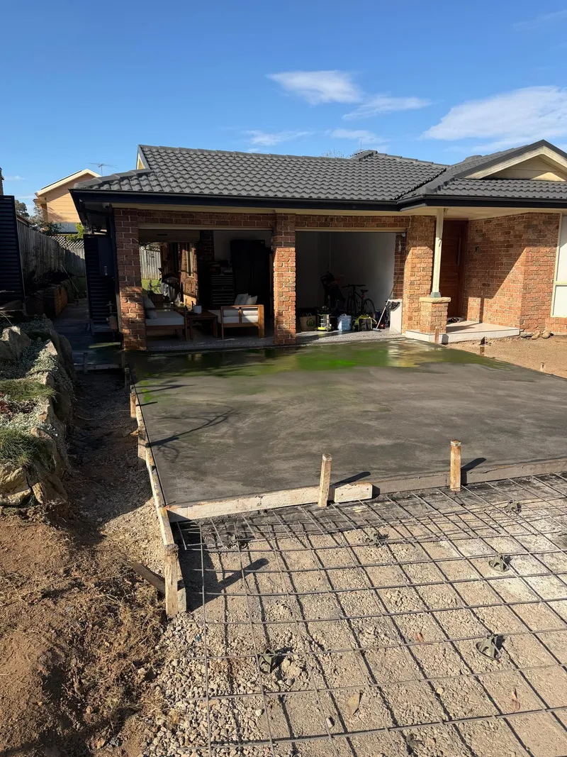 The new 'Emperor' exposed aggregate driveway freshly poured, with the council crossover reinforcement prepped in the foreground