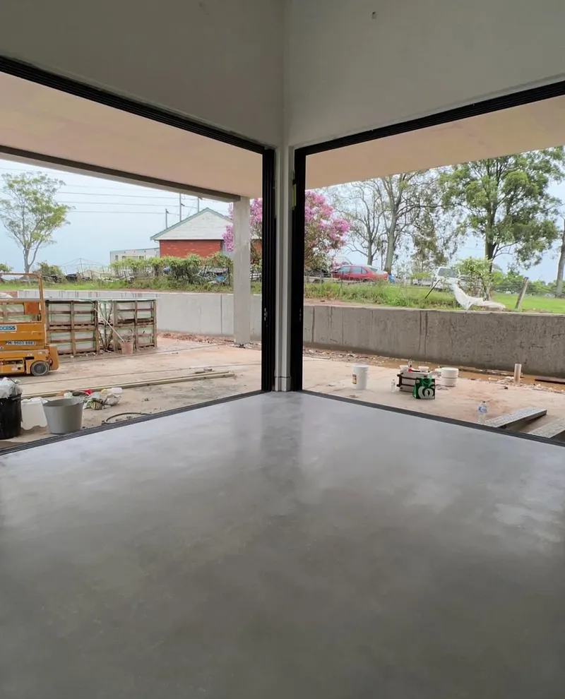 Burnished concrete floor at the corner of two floor-to-ceiling window bays, Horsley Park
