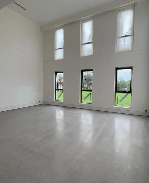 Burnished concrete floor inside a double-height living space in Horsley Park, NSW