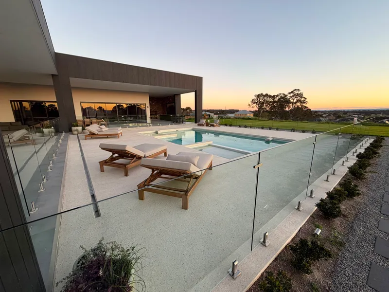Overview of the Horsley Park pool area showing the full exposed aggregate surround and glass pool fencing
