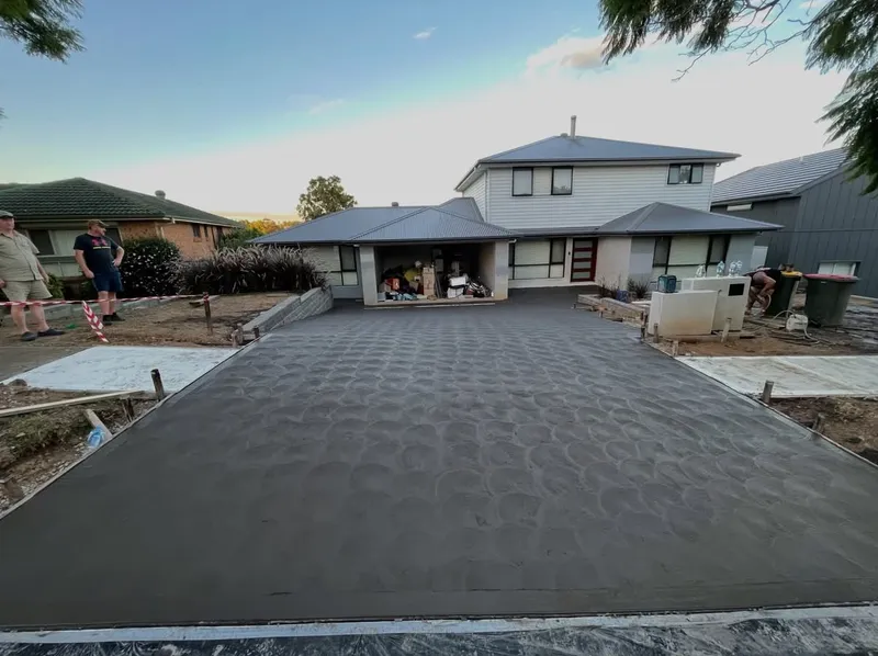 Wide street view of the finished charcoal driveway with a coved finish at a home in Lalor Park, NSW