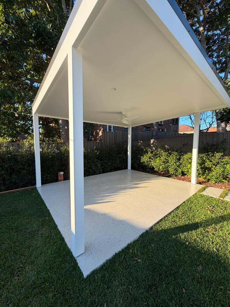 The Matraville cabana slab seen from the lawn, the honed surface running out to the grass edge