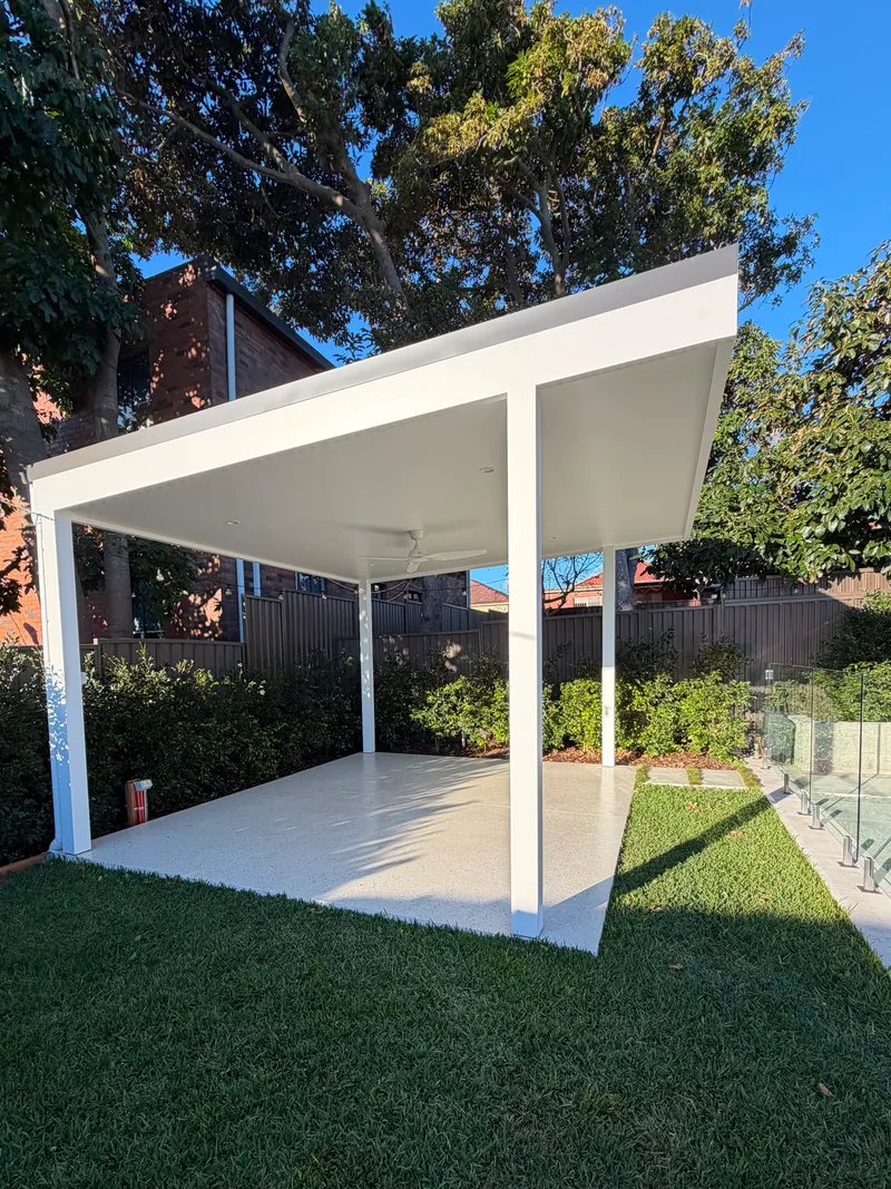 The white cabana at Matraville sitting on its honed concrete slab, with lawn on all sides
