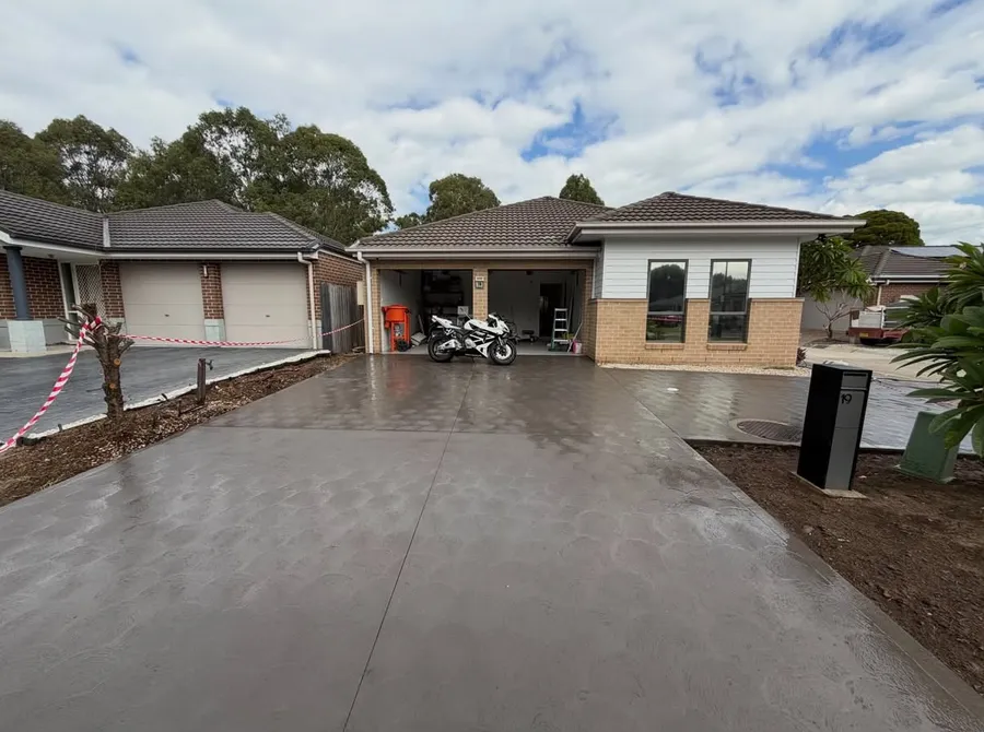 Finished charcoal concrete driveway with a coved finish at a home in Oakhurst, NSW