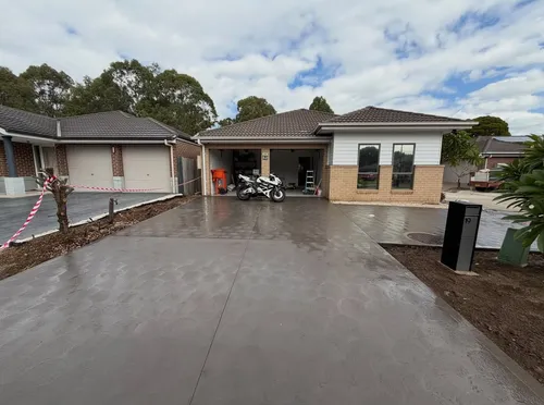 Finished charcoal concrete driveway with a coved finish at a home in Oakhurst, NSW