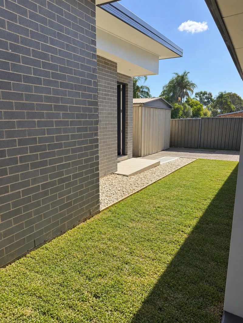 The ramp and pebble garden bed running alongside the house at Old Toongabbie, with turf laid to the lawn