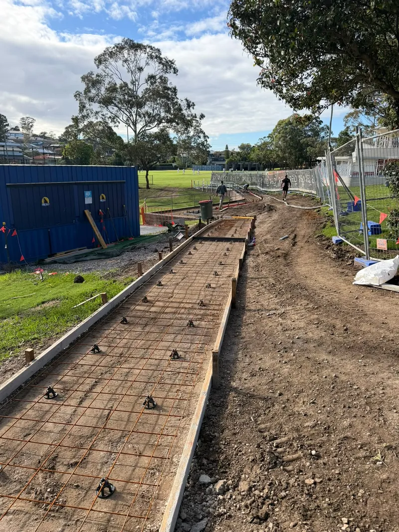 A section of the path part-poured, with reinforcement still exposed further along the curve