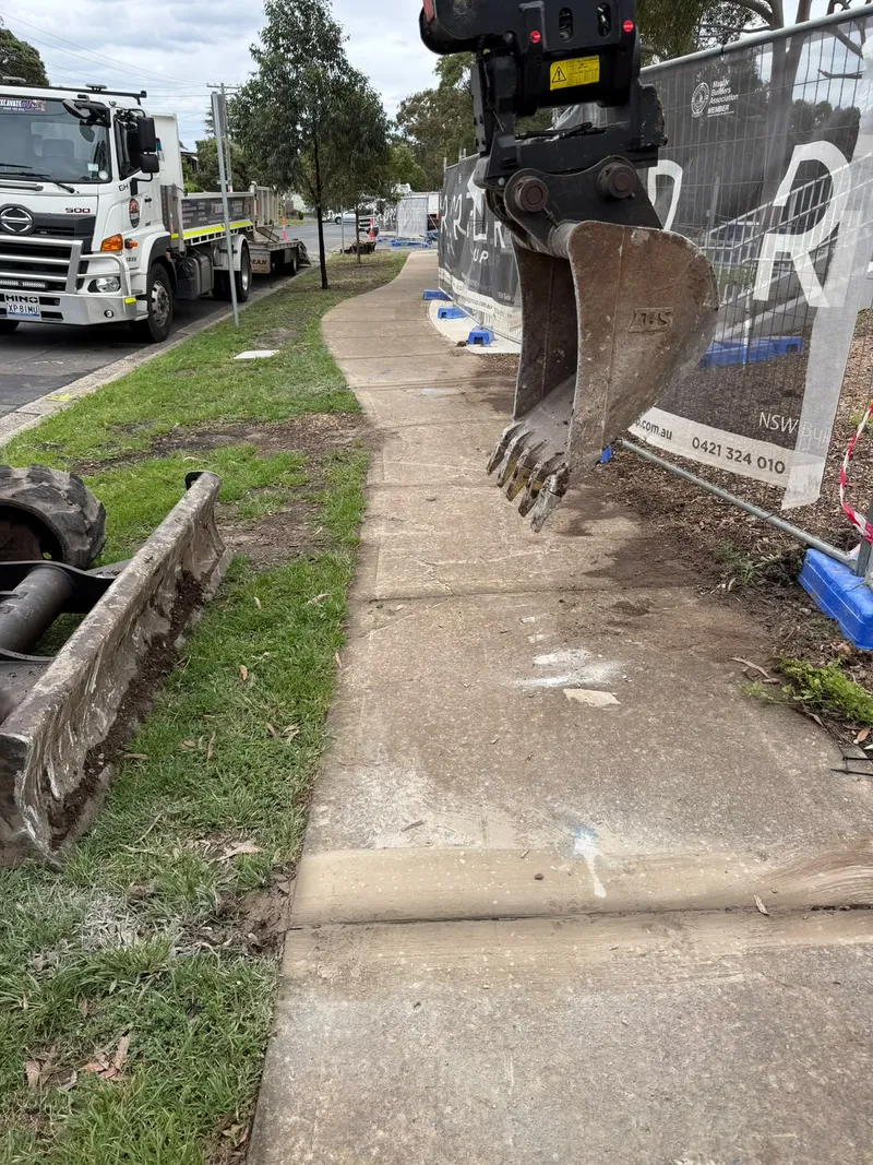 The excavator alongside the finished footpath at Max Ruddock Reserve, with the delivery truck on site